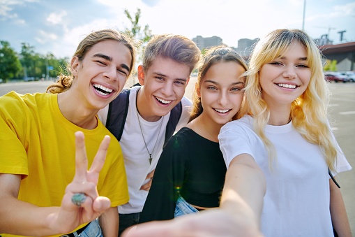 Group of happy teenage friends taking selfie photo. Best friends having fun together outdoor looking at camera. Youth, friendship, teens, adolescence, fun, joy concept