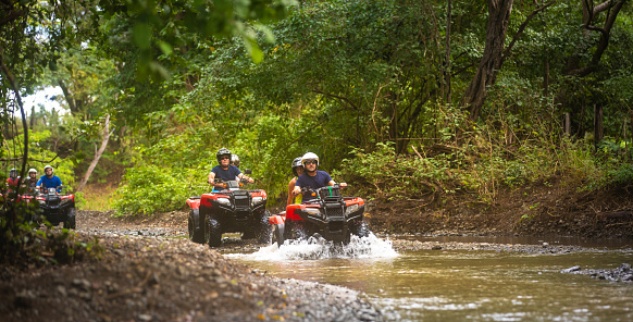 Group of hispanic tourists driving 4x4 vehicles in Costa Rica