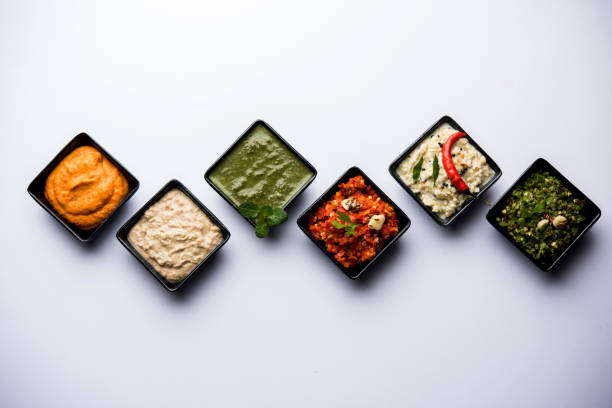 Group of Indian Chutneys includes coconut, Peanut, green and red chilly, garlic and pudina served in small square shape bowls. selective focus Group of Indian Chutneys includes coconut, Peanut, green and red chilly, garlic and pudina served in small square shape bowls. selective focus chutney stock pictures, royalty-free photos & images