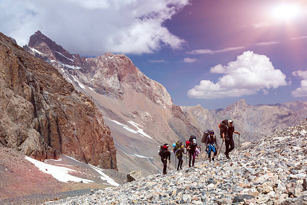 Group of Mountaineer Walking on Deserted Rocky Terrain stock photo