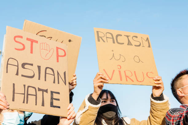 Group of multiracial people protest on the street against racism - Demonstrators from different asian countries fight for equal rights - Stop asian hate fight campaign concept stock photo