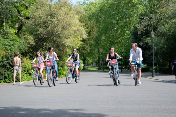 A group of people cycling in the park during social distancing stock photo