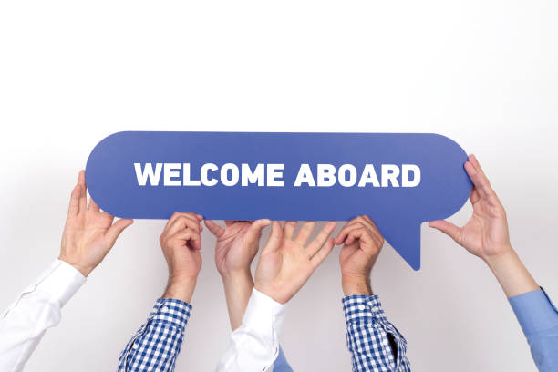 Group of people holding the WELCOME ABOARD written speech bubble stock photo