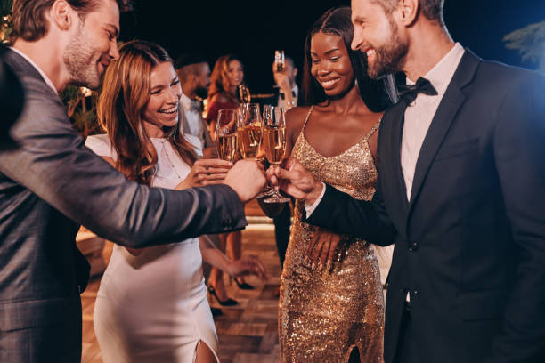 Group of people in formalwear toasting with champagne and smiling Group of people in formalwear toasting with champagne and smiling while spending time on luxury party evening  dress stock pictures, royalty-free photos & images