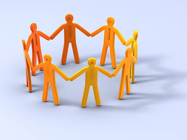 Group of people stand in circle holding hands stock photo