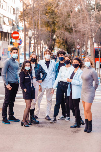 Group of people standing outside wearing protective face masks stock photo