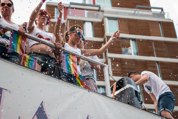 Valencia, Spain - June 16, 2018: A group of people throwing confetti from a float, during the gay pride day parade in a float stock photo