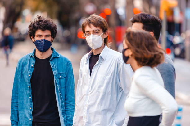 Group of people wearing protective face masks conversating on the street stock photo