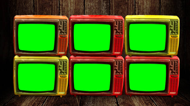 Group of retro television with green screen at wooden floor and wall background stock photo