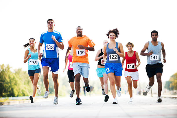 Group of runners in a cross country race. Cheerful group of marathon runners.    marathon photos stock pictures, royalty-free photos & images