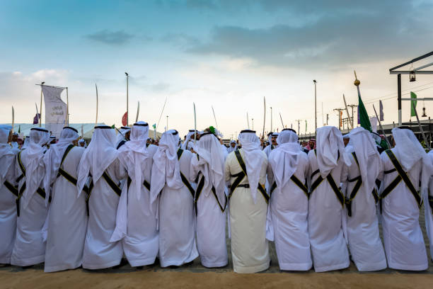 A group of Saudi Arabs performing traditional saudi arabian dance in Abqaiq Desert Safari Festival Saudi Arabia 10th January 2020. Selective focused on the subject background blurred. stock photo