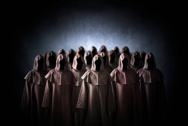 Group of scary figures in hooded cloaks stock photo
