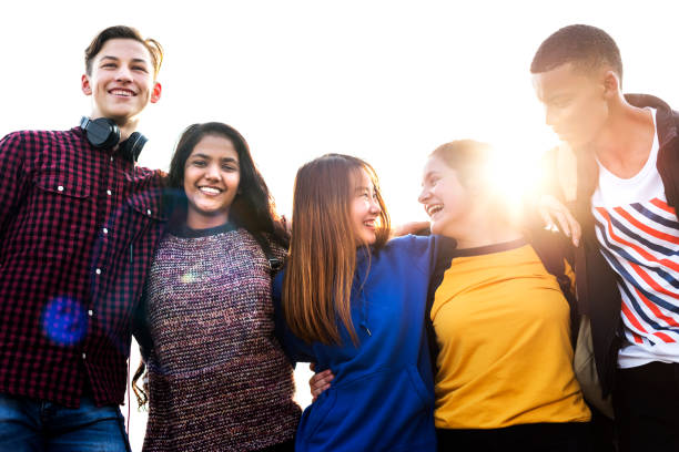 Group of school friends outdoors arms around one another togetherness and community concept Group of school friends outdoors arms around one another togetherness and community concept arm around stock pictures, royalty-free photos & images
