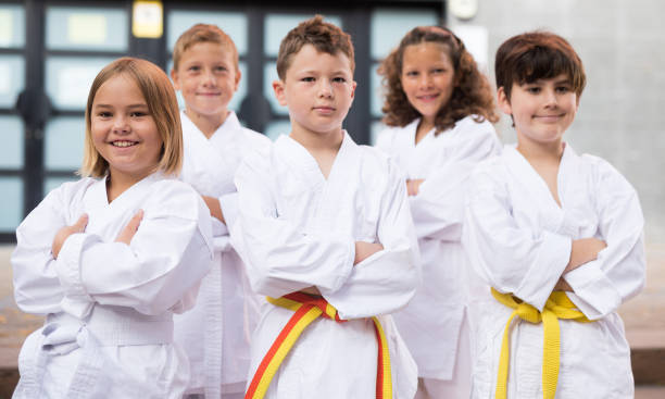 Group of schoolchildren practicing karate at schoolyard stock photo