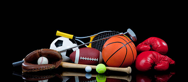 Group of sports equipment from various sports A group of assorted sports equipment on a black background with baseball supplies, soccer ball, boxing gloves, tennis ball and racket and a basketball and football sporting goods stock pictures, royalty-free photos & images