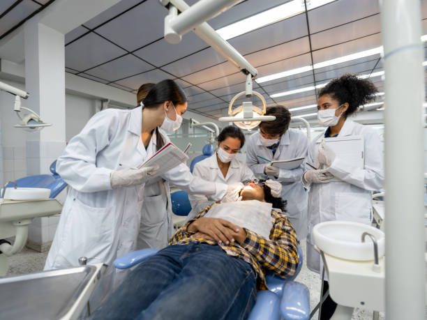 group of students at dental school watching a dentist examining a patient - aluno dentista imagens e fotografias de stock
