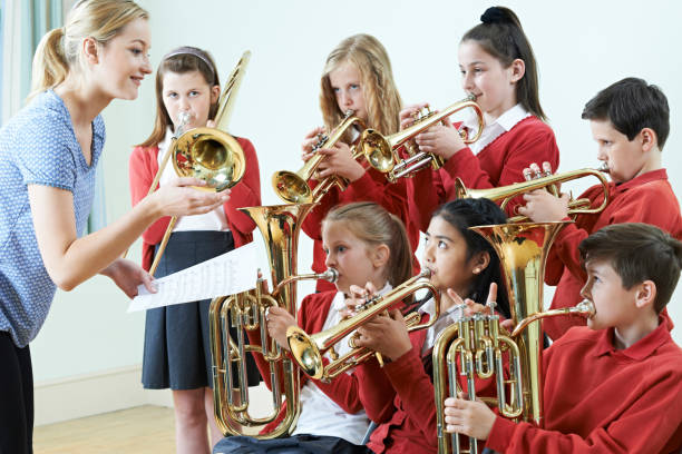 Group Of Students Playing In School Orchestra Together Group Of Students Playing In School Orchestra Together brass photos stock pictures, royalty-free photos & images