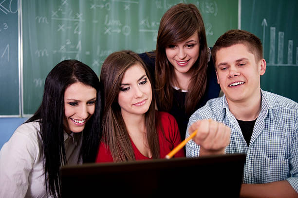 Group of students using computer  college students in classroom stock pictures, royalty-free photos & images