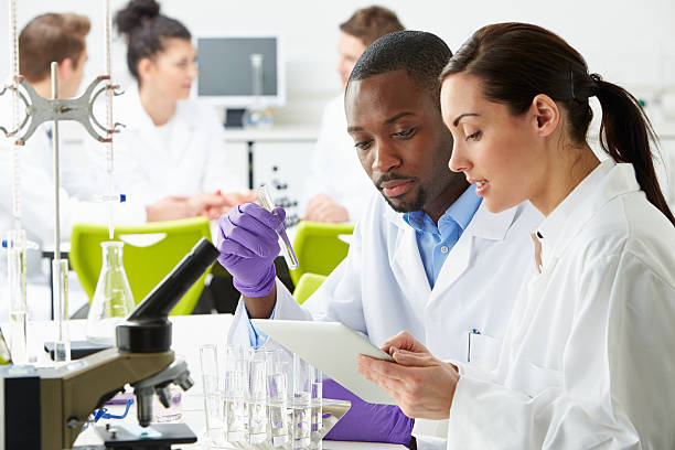 Group Of Technicians Working In Laboratory stock photo