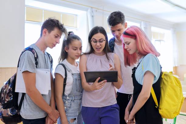 group-of-teenage-students-and-young-female-teacher-with-digital-in-picture-id1278724191?k=20&m=1278724191&s=612x612&w=0&h=vR_Lqnkf07GmvlhbrEy8ODYUNgpr1PsxD8Uwyopp57s=