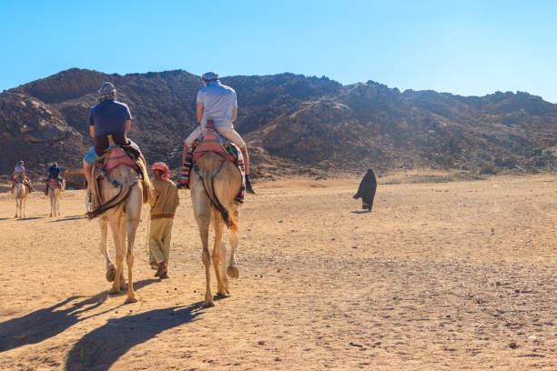 Group of tourists riding camels in Arabian desert, Egypt Hurghada, Egypt - December 10, 2018: Group of tourists riding camels in Arabian desert, Egypt hot middle eastern women stock pictures, royalty-free photos & images