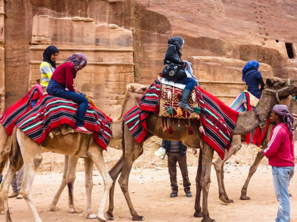 Group of tourists riding camels, Petra (Rose City) stock photo