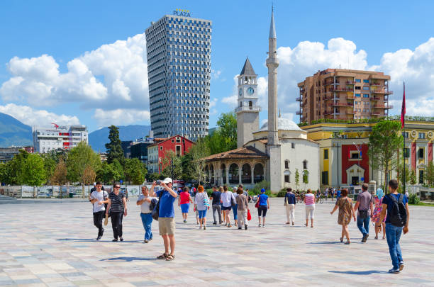 Group of unknown tourists on Skanderbeg square. Efem Bey Mosque, Clock Tower, Plaza Hotel, Tirana, Albania stock photo
