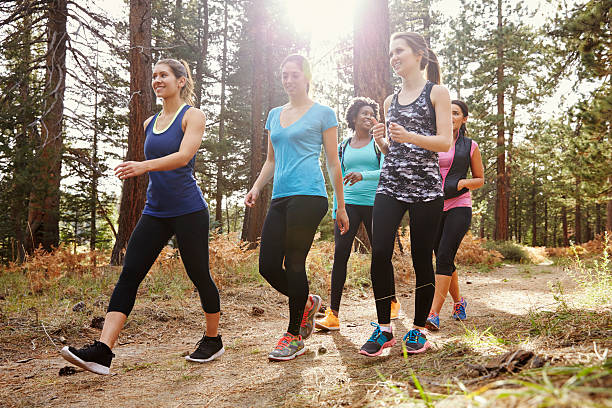 group of women runners walking in a forest, close up - wandelen lichaamsbeweging stockfoto's en -beelden