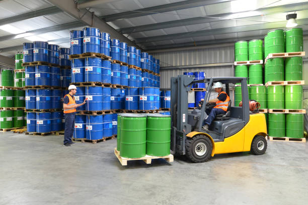 group of workers in the logistics industry work in a warehouse with chemicals - lifting truck group of workers in the logistics industry work in a warehouse with chemicals - lifting truck oil refinery factory stock pictures, royalty-free photos & images