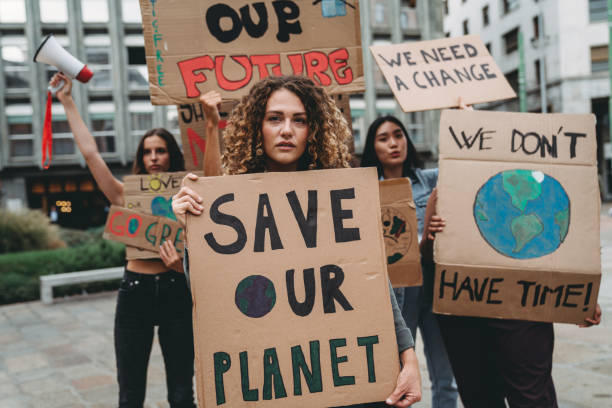 A group of young adult people are marching together on strike against climate change