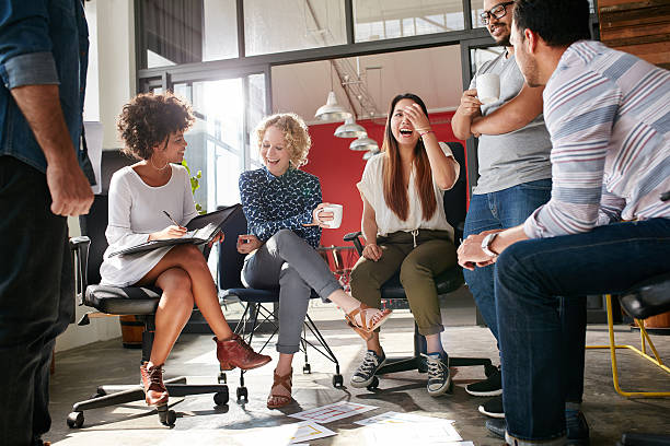 Group of young business professionals having a meeting Shot of a group of young business professionals having a meeting. Diverse group of young designers smiling during a meeting at the office. business casual stock pictures, royalty-free photos & images