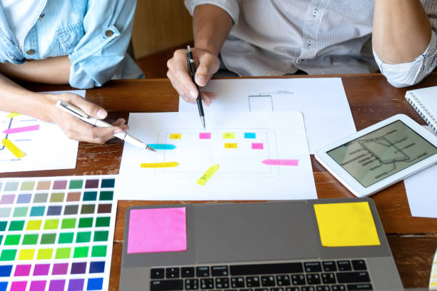 Group of young designer working in the office to design a new product, use color chart and computer laptop for new smartphone design concept stock photo