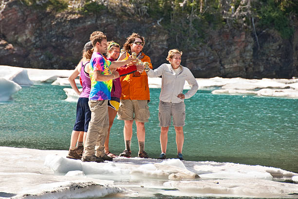 Standing on an Iceberg Glacier National Park, Montana, USA - August 16, 2013: A group of young people drink beer while standing on the ice at Iceberg Lake. jeff goulden people stock pictures, royalty-free photos & images