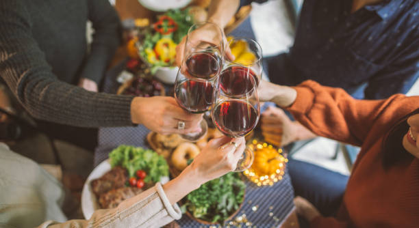 Group of young people enjoying dinner together. Dining Wine Cheers Party thanksgiving Concept Group of young people enjoying dinner together. Dining Wine Cheers Party thanksgiving Concept asian family eating together stock pictures, royalty-free photos & images