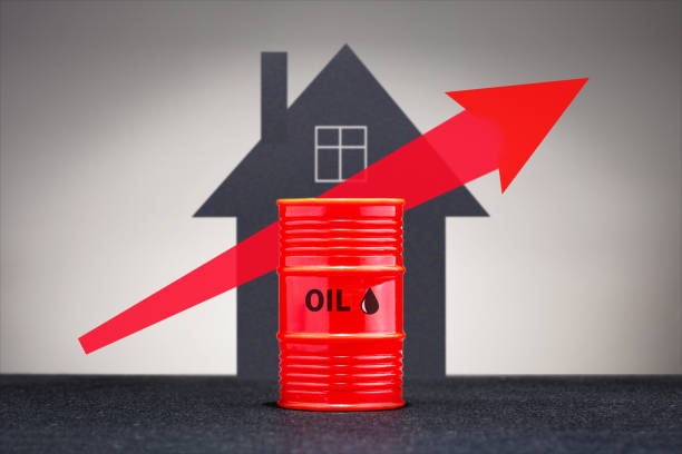 Growing oil prices concept. Barrel with heating fuel on the background of house. stock photo