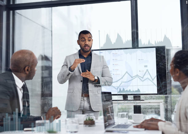 Growth is up to us Shot of a young businessman delivering a presentation to his colleagues in the boardroom with cgi graphs superimposed against them body language course stock pictures, royalty-free photos & images