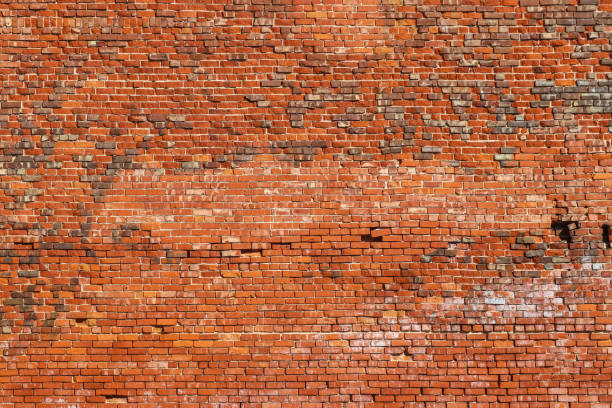 Grunge brick background with various colored bricks and remnants of white paint and a few missing or damaged - interesting design stock photo