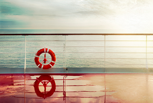 Grunge cruise deck background at dawn.Lifebuoy hand railing deck. Vintage look.