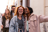 istock Gruop of multiracial friends walking and smiling 1391394055
