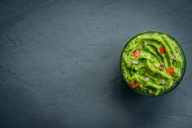 Guacamole bowl on a stone table. Top view image. Copyspace for your text. stock photo