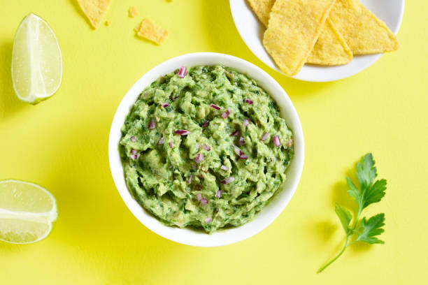 Guacamole dip Guacamole dip in bowl over yellow background. Healthy avocado spread. Top view, flat lay guacamole stock pictures, royalty-free photos & images