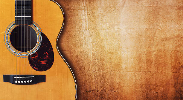Guitar and blank grunge background Acoustic guitar resting against a blank grunge background with copy space acoustic guitar stock pictures, royalty-free photos & images