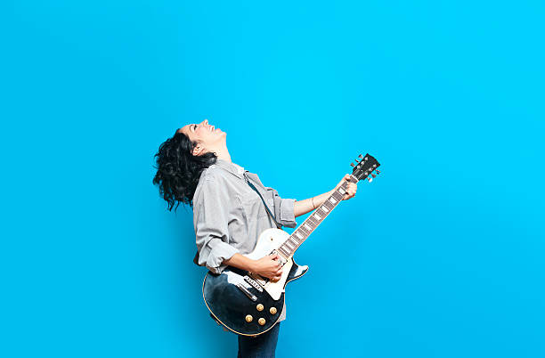 Guitar Chic Guitar player against a blue background singer stock pictures, royalty-free photos & images