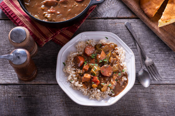 Gumbo Sausage Gumbo Over Rice on Rustic Wood Table gumbo stock pictures, royalty-free photos & images