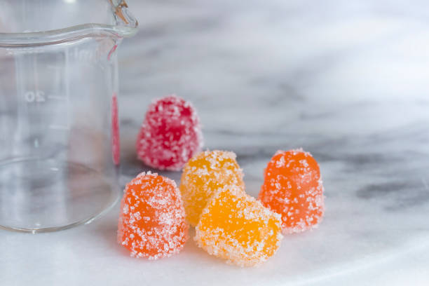 CBD gummy candy gumdrops on a white marble surface stock photo