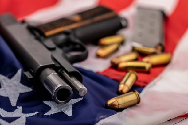 pistola y balas en un fondo de bandera estadounidense - gun violence fotografías e imágenes de stock