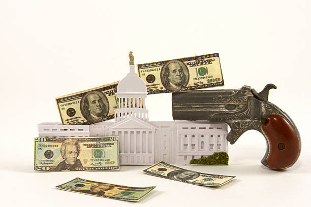Gun Lobby US Congress building with hand gun and american currency nra stock pictures, royalty-free photos & images