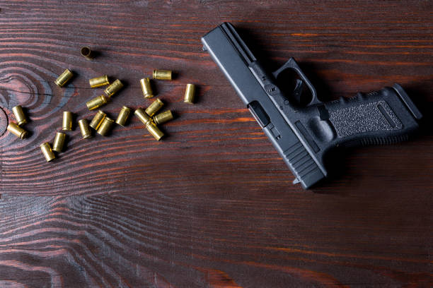 пистолет на деревянном столе - gun violence стоковые фото и изображения