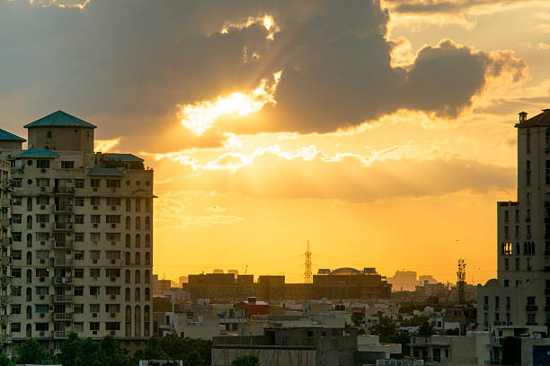 Gurgaon apartments at sunset Gurgaon apartments at sunset with light rays passing through the clouds and giving a golden glow haryana stock pictures, royalty-free photos & images