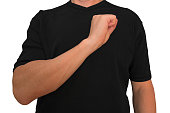 Guy keeps arm on breast near heart with fist. Gesture of man in black t-shirt isolated with no face. Concept of vigor and resoluteness